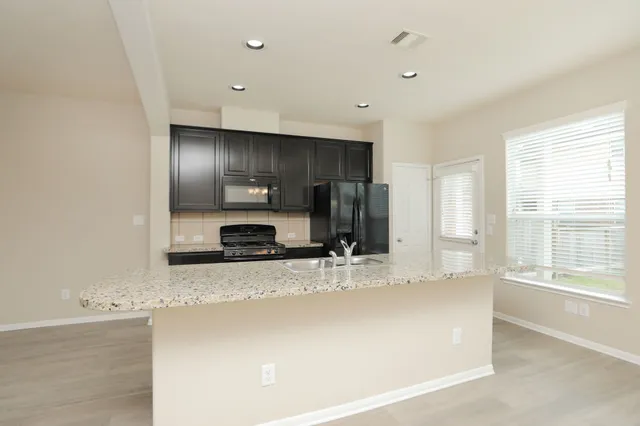 a view of a kitchen with a sink and a large window