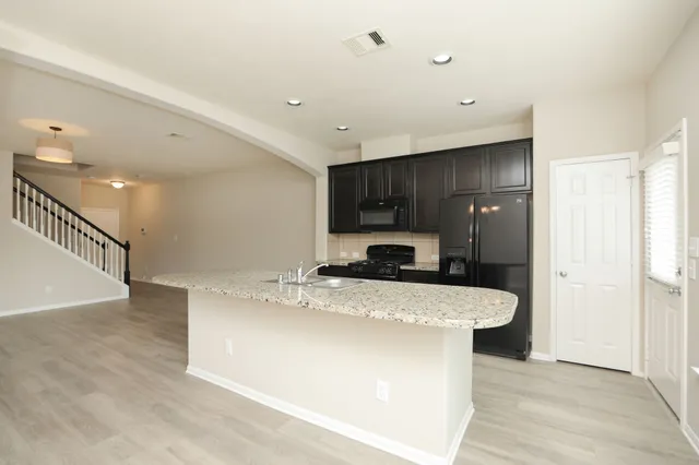 a kitchen with stainless steel appliances granite countertop a sink a stove and a refrigerator