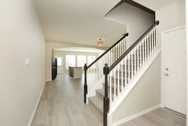 a view of staircase with lots of frames on wall and wooden floor