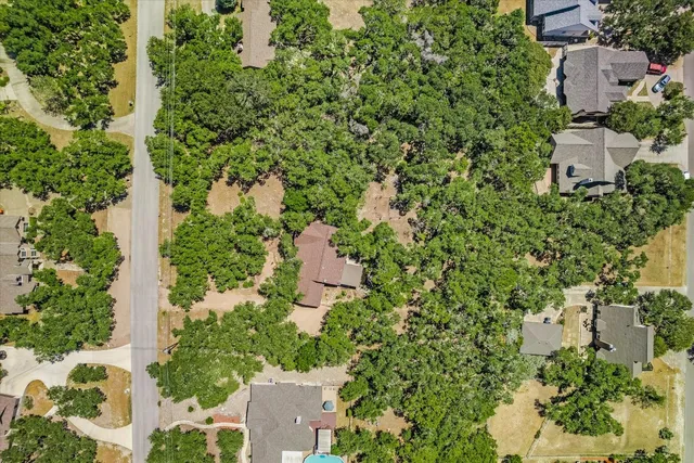 an aerial view of residential house with outdoor space and trees all around