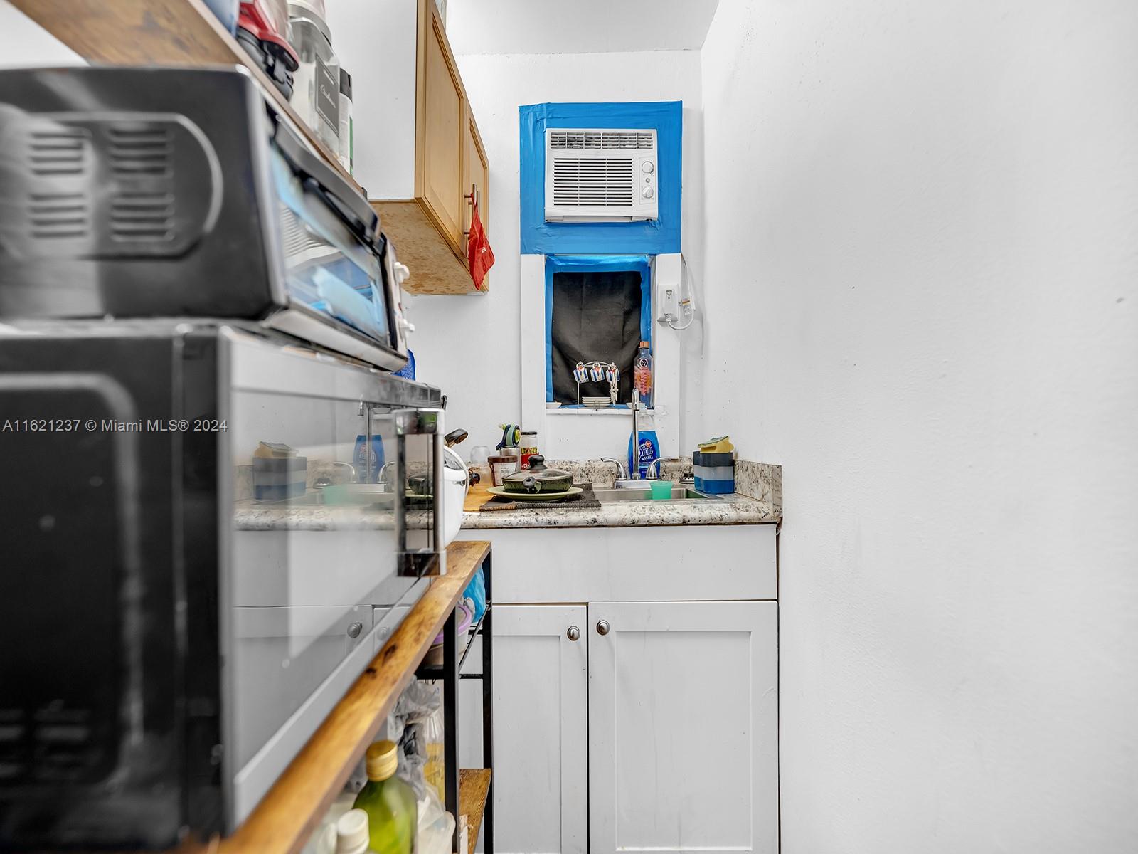 700 Northeast 6th Street Hallandale Beach, FL 33009 - Photo 11 of 15 a kitchen with a sink a refrigerator and cabinets