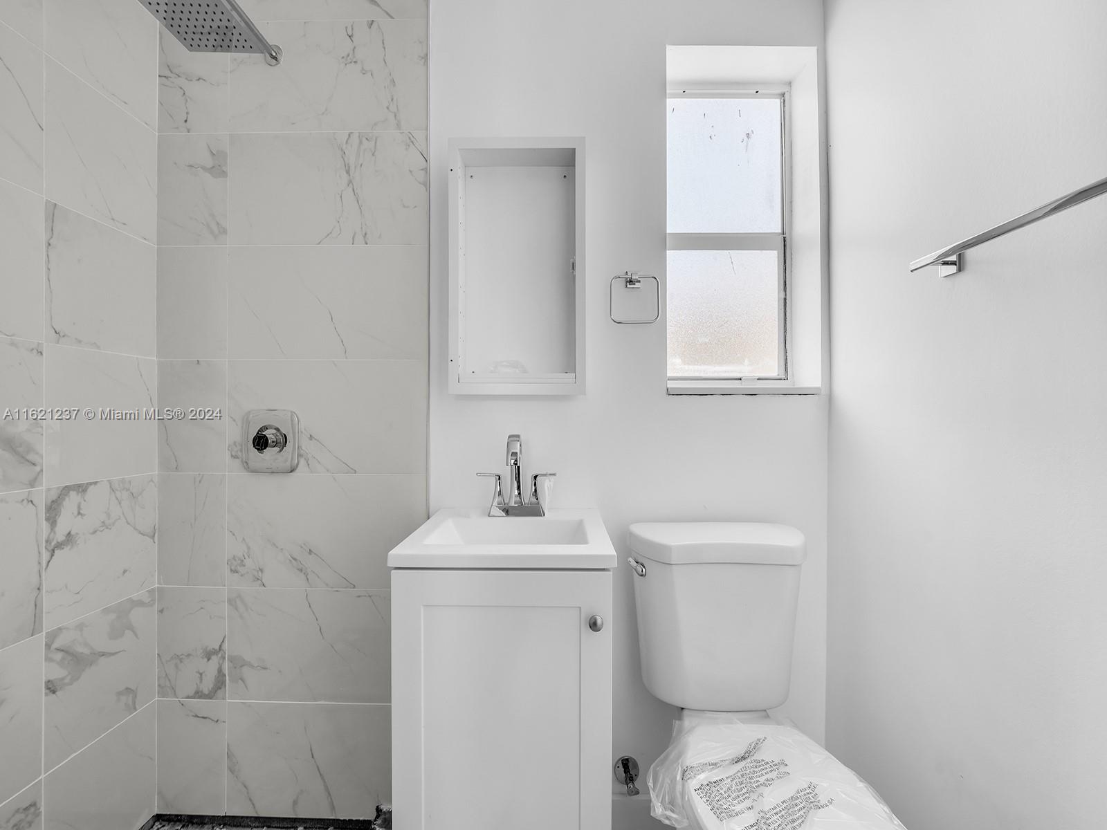 700 Northeast 6th Street Hallandale Beach, FL 33009 - Photo 8 of 15 a bathroom with a toilet sink and mirror