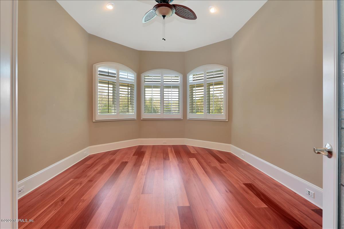 96270 Captains Pointe Road Yulee, FL 32097 - Photo 17 of 34 an empty room with wooden floor chandelier fan and windows