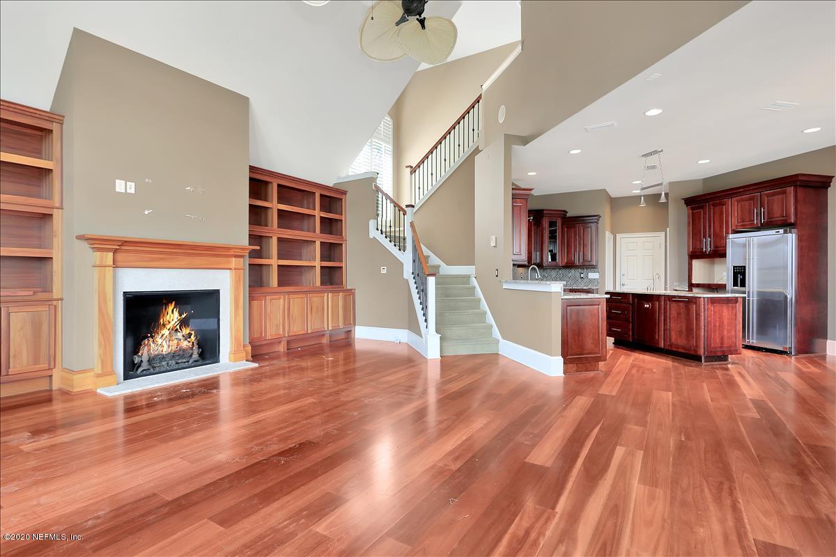 96270 Captains Pointe Road Yulee, FL 32097 - Photo 3 of 34 a living room with stainless steel appliances kitchen island wooden floors and a fireplace