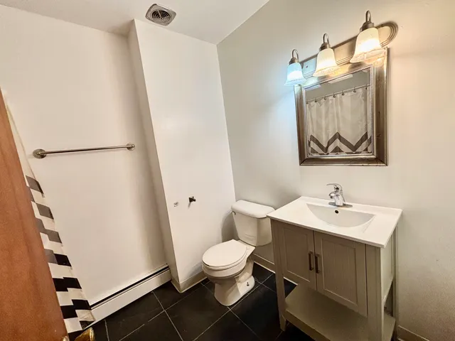 a bathroom with a sink a toilet and a mirror