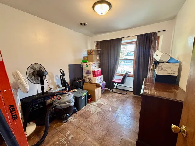a view of a workspace with furniture and a window