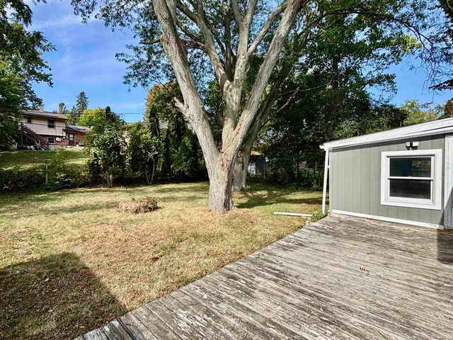 a view of backyard of house with green space
