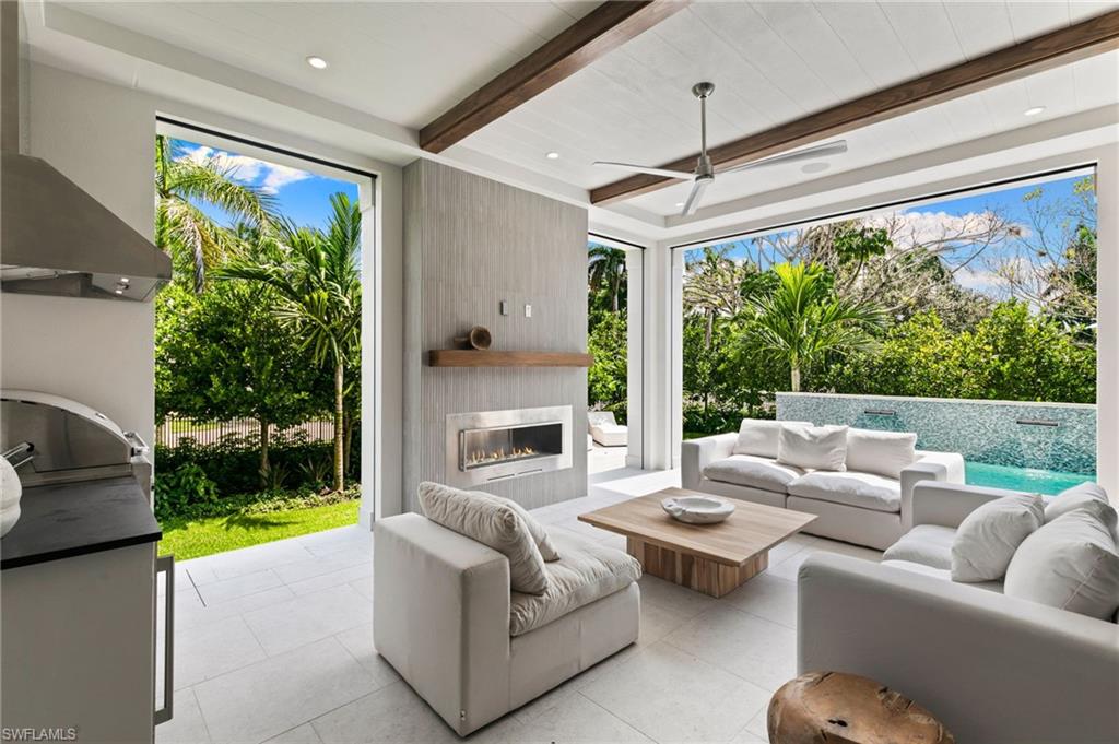 1191 7th Avenue North Naples, FL 34102 - Photo 19 of 49 Outdoor Living features Fireplace, Kitchen and beamed ceiling overlooking the Pool