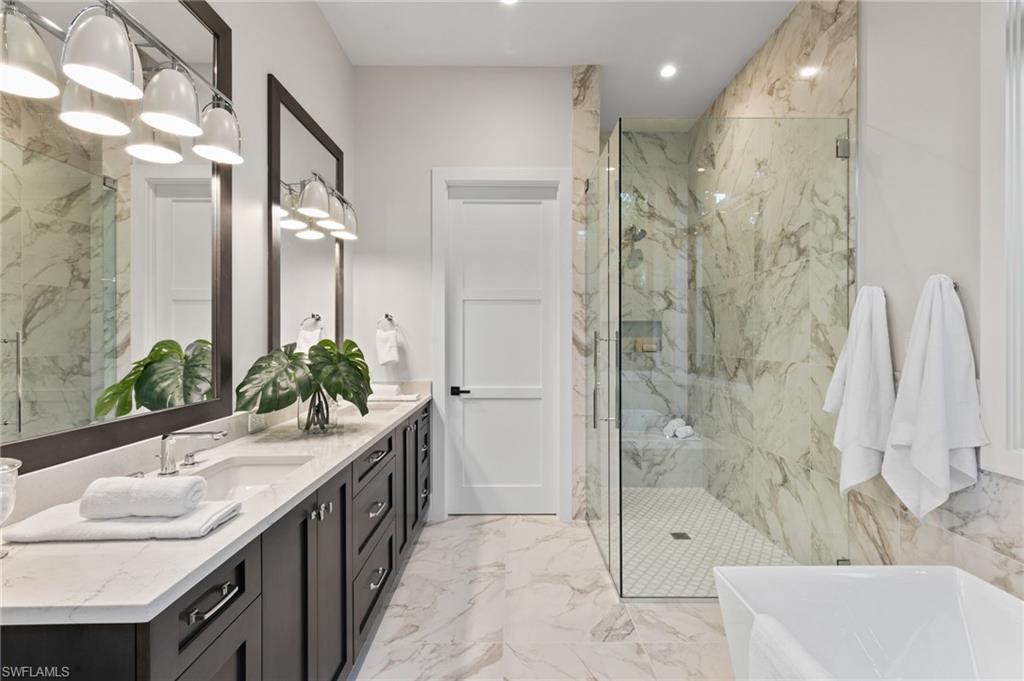 1191 7th Avenue North Naples, FL 34102 - Photo 28 of 49 Primary Bath with Exquisite Porcelain Marble-Look Tile and Private Water Closet