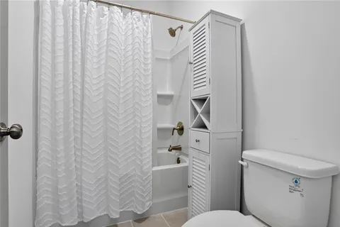 a bathroom with a toilet and a shower curtain