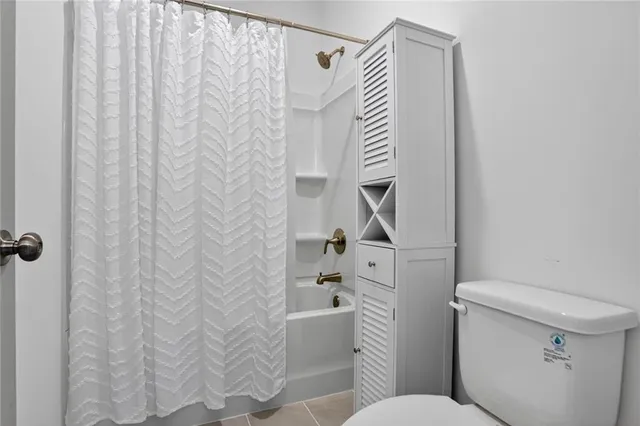 a bathroom with a toilet and a shower curtain