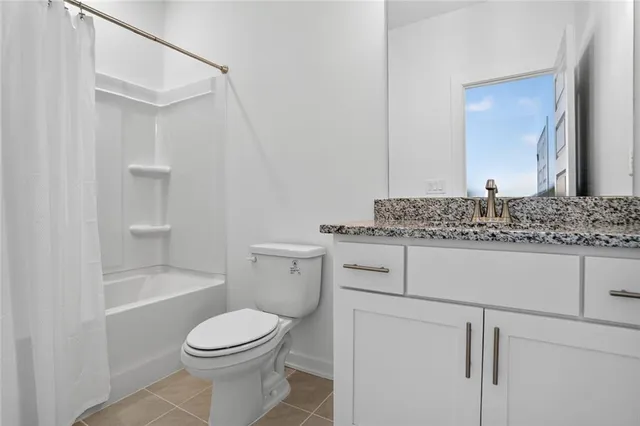 a bathroom with a granite countertop toilet sink and mirror