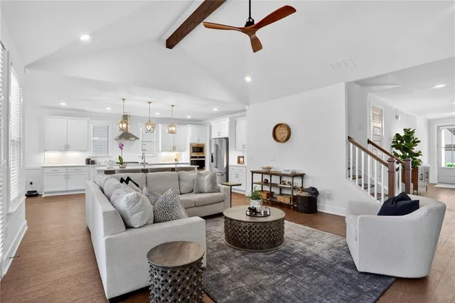a living room with furniture kitchen view and a potted plant