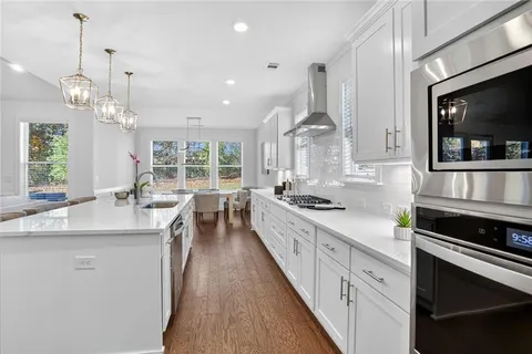a kitchen with stainless steel appliances a stove sink and cabinets