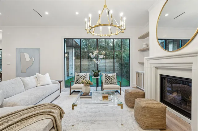 a living room with furniture chandelier and a large window
