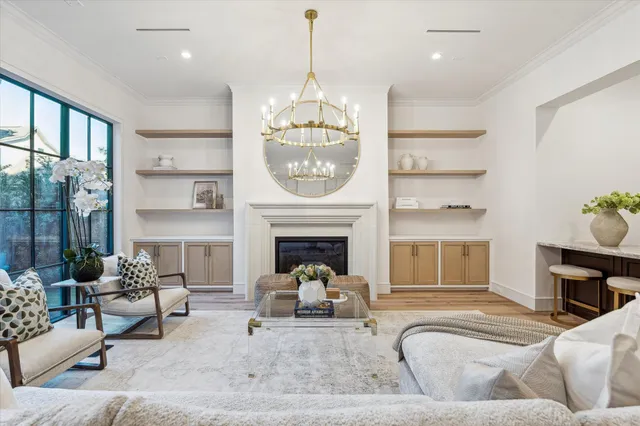 a living room with furniture a fireplace and a chandelier