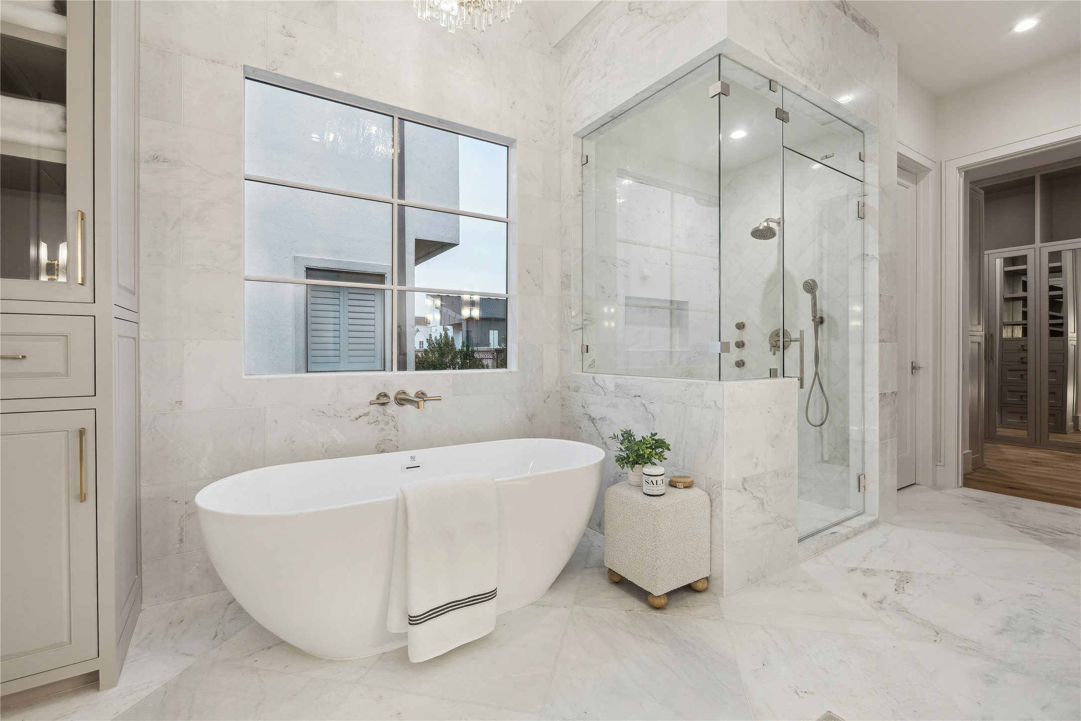 1210 West Drew Street Houston, TX 77006 - Photo 25 of 35 The freestanding soaking tub with wall-mounted hardware and spacious shower. Polished gold fixtures maintain the luxurious feel, coupled with the marble detailing throughout. A handheld sprayer and trio of body jets create a spa-like feel from your very own home.