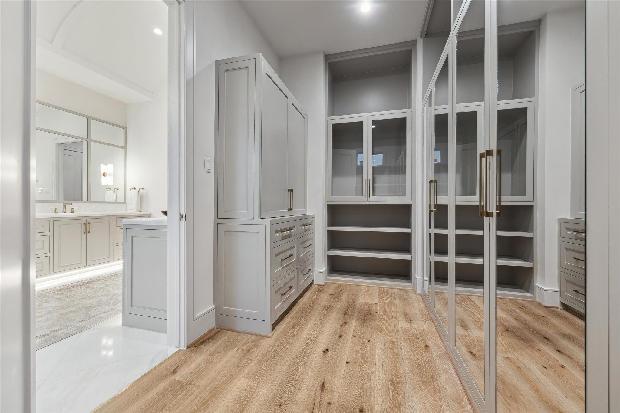 1210 West Drew Street Houston, TX 77006 - Photo 26 of 35 The primary closet. Wardrobe boxes with custom-fabricated doors exude a fashion house feel. Soft-close hinges are another element of quiet luxury. Accessory shelves are thoughtfully placed for purses, shoes, and more!