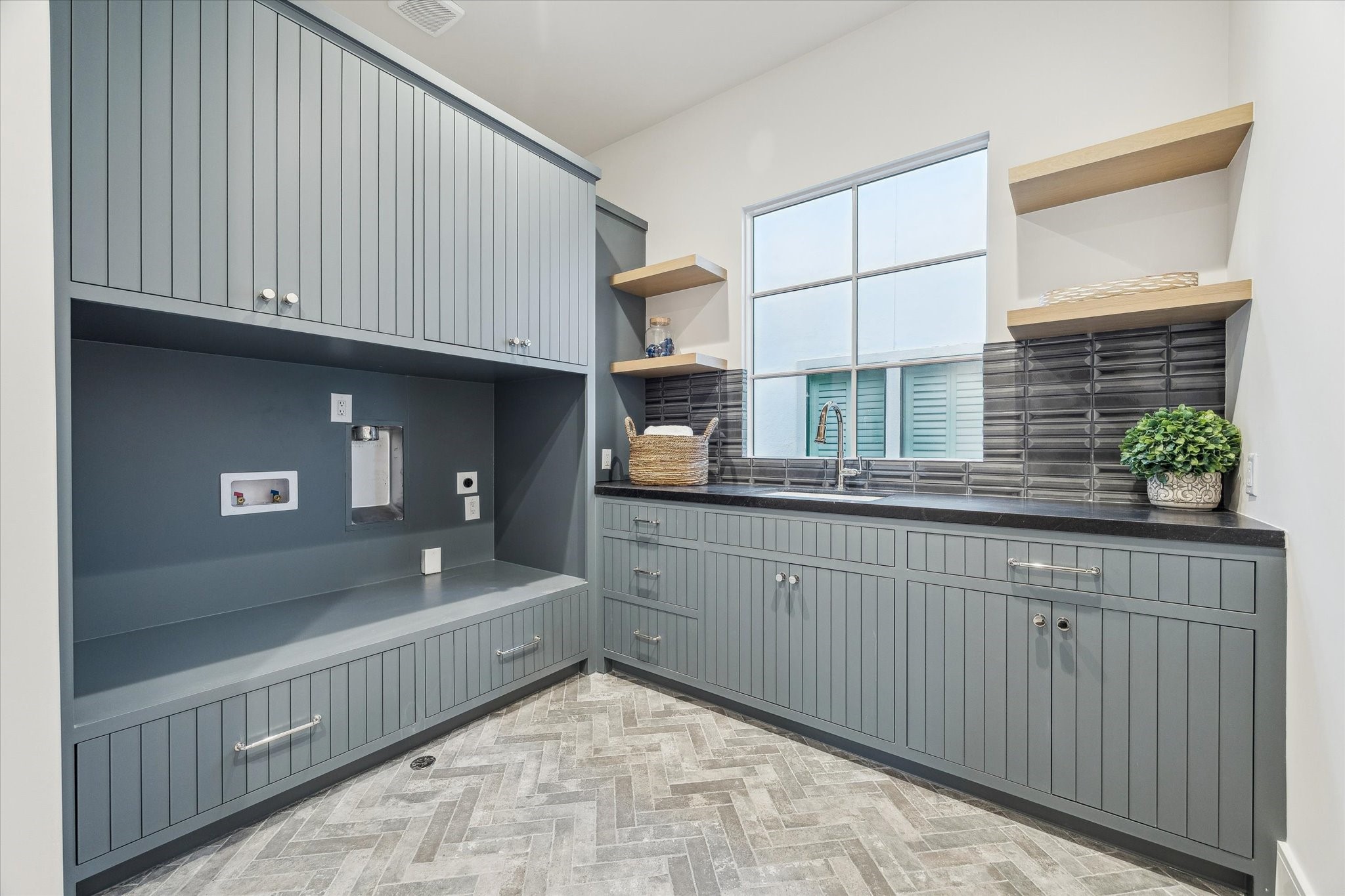 1210 West Drew Street Houston, TX 77006 - Photo 31 of 35 The lavish laundry room, with wood paneling and a huge window! The assortment of cabinets, drawers, and shelves will house detergents, dryer balls, and more. The herringbone brick flooring adds a great feel to the room.