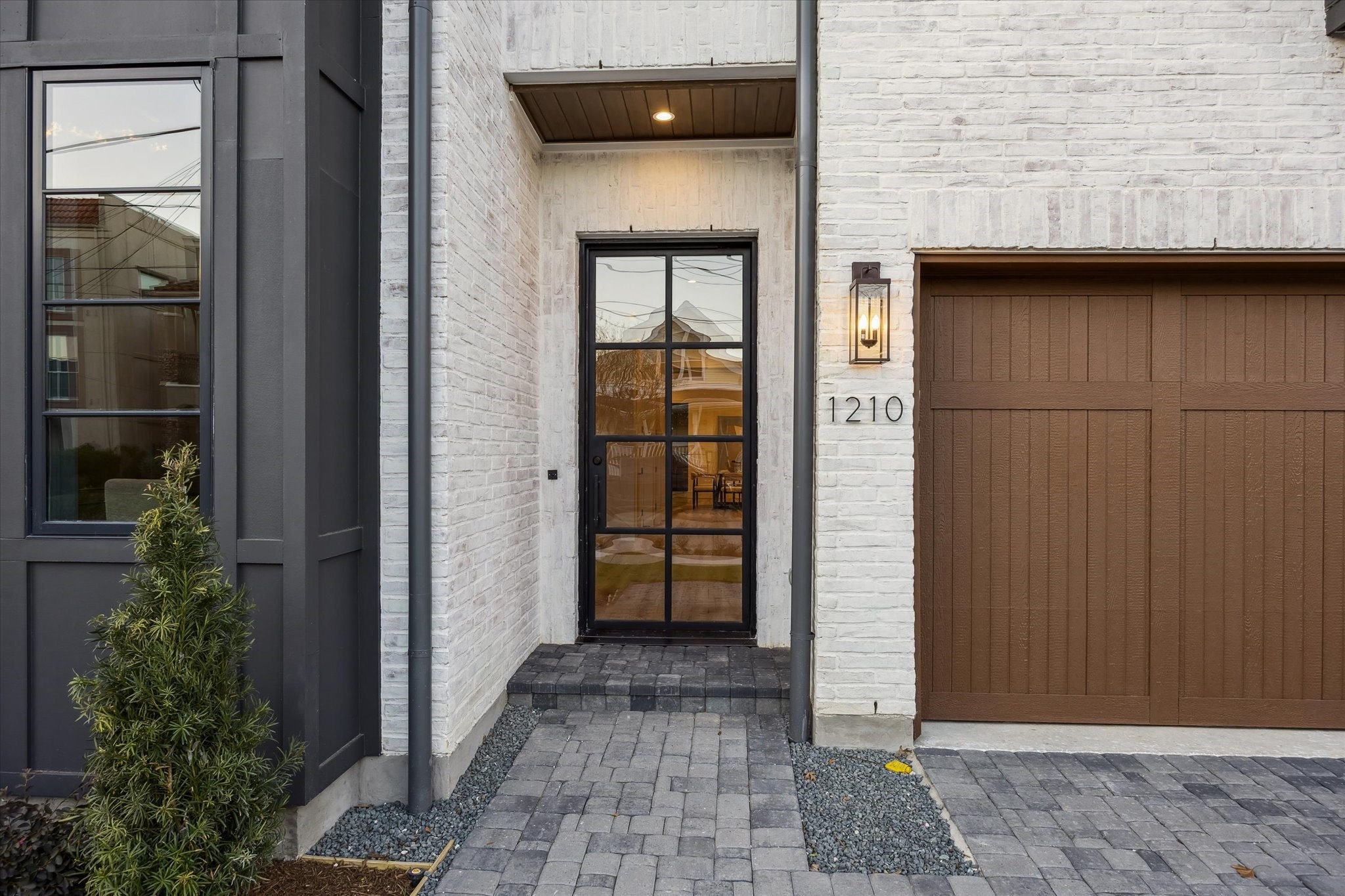 1210 West Drew Street Houston, TX 77006 - Photo 7 of 35 The front entrance features brick, pavers, and contrasting garage door and architectural elements. Pavers line the path and a dramatic obsidian steel pivot door previews the splendor to come!