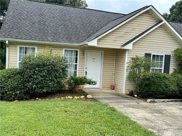 a front view of a house with a garden