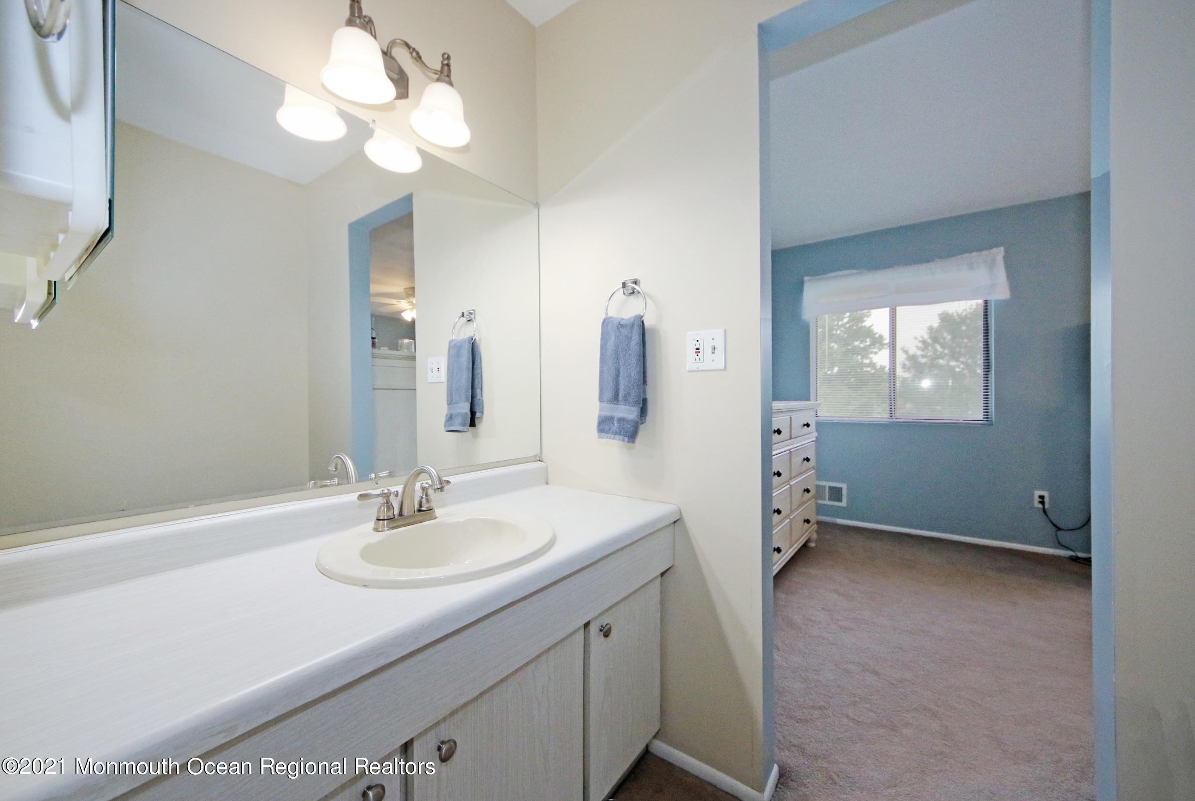 373 Middlewood Road Middletown, NJ 07748 - Photo 21 of 28 a bathroom with a sink a mirror and a shower