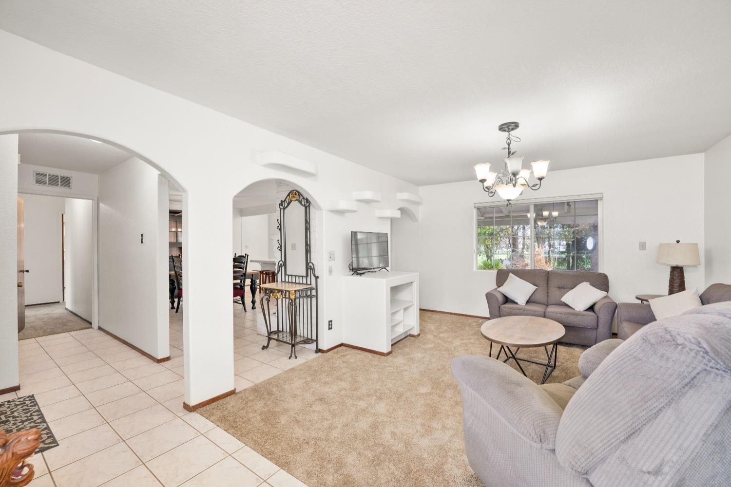 a living room with fireplace furniture and a chandelier