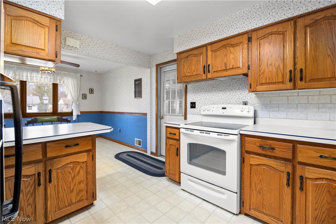 36141 Aurensen Road North Ridgeville, OH 44039 - Photo 7 of 24 Kitchen with electric range, light floors, and backsplash