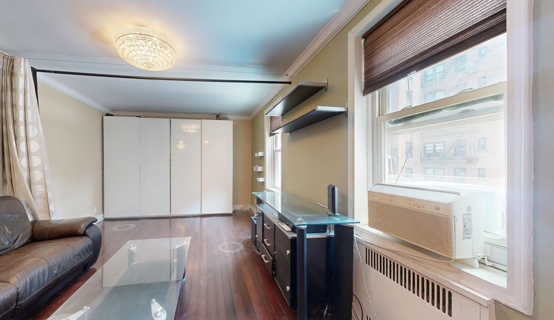 94-10 64th Road, Unit B6 Queens, NY 11374 - Photo 3 of 17 Living room featuring radiator, ornamental molding, and dark wood-style floors