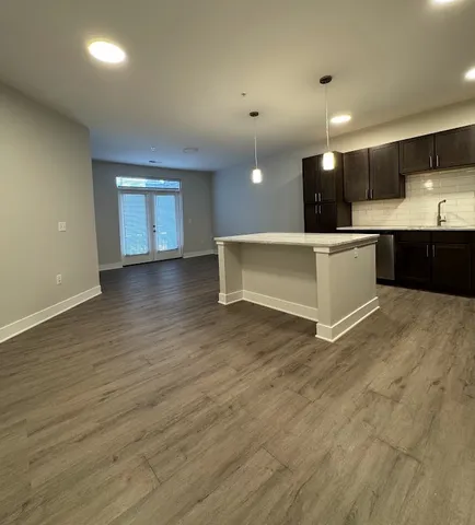 a large kitchen with stainless steel appliances a large counter top and wooden cabinets