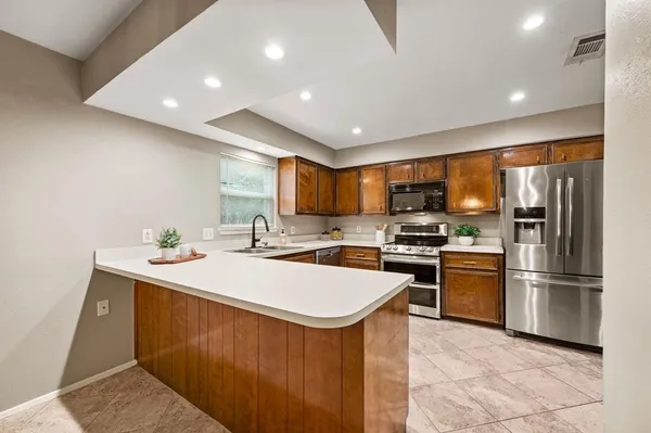 a kitchen with stainless steel appliances a stove microwave and refrigerator