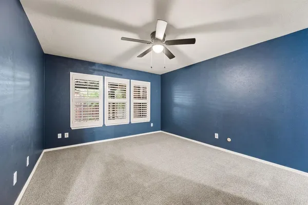 an empty room and chandelier fan
