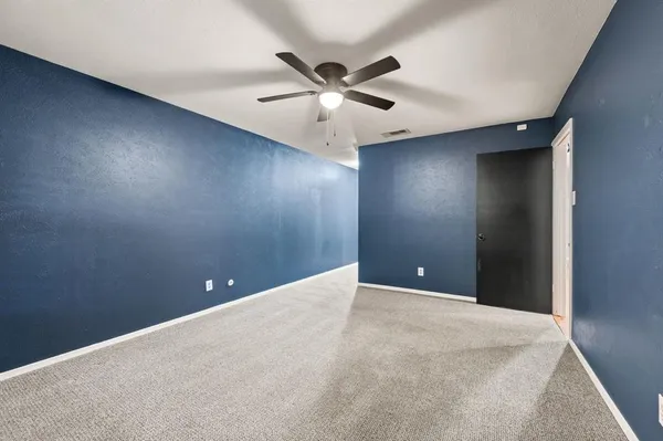 a view of an empty room with a ceiling fan