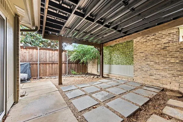 a view of a backyard with plants and large trees