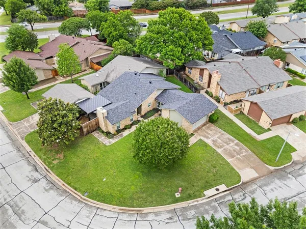 an aerial view of a house with garden space and a building