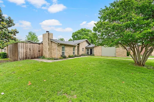 a front view of house with a garden