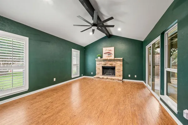a view of a livingroom with a fireplace a ceiling fan and front door