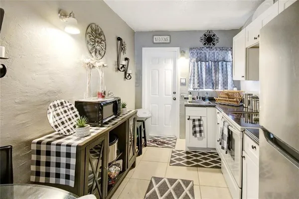 a kitchen with stainless steel appliances a stove a sink a chimney and a dining table