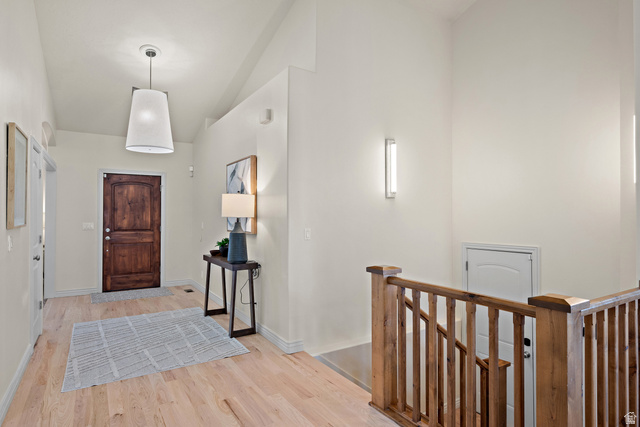 927 Iris Lane Mapleton, UT 84664 - Photo 3 of 31 Vaulted ceilings, wood-finish flooring, dark wood entry door, and wood railing