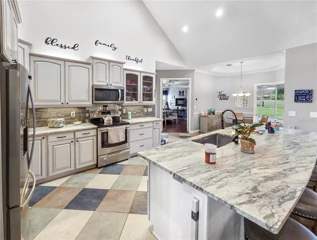 a kitchen with stainless steel appliances granite countertop a sink stove and cabinets
