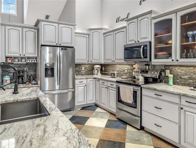 a kitchen with stainless steel appliances granite countertop a refrigerator sink and stove