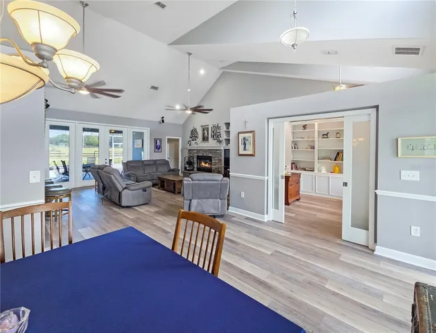 a living room with furniture kitchen view and a wooden floor