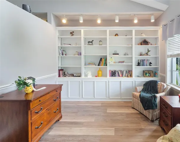 a kitchen with stainless steel appliances granite countertop a shelf and a wooden floors