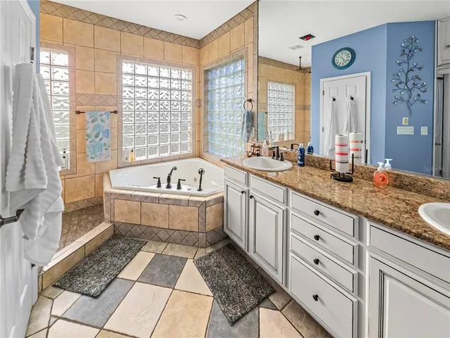 a spacious bathroom with double vanity and a bathtub