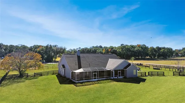 an aerial view of a house with swimming pool and mountains