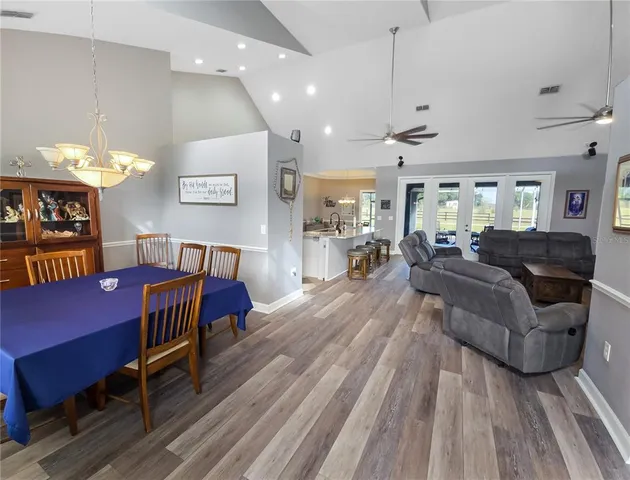 a living room with furniture a dining table and a piano