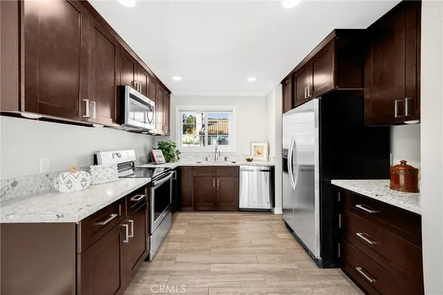 a kitchen with stainless steel appliances granite countertop a sink stove and refrigerator