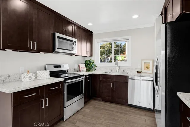 a kitchen with stainless steel appliances granite countertop a sink stove and refrigerator
