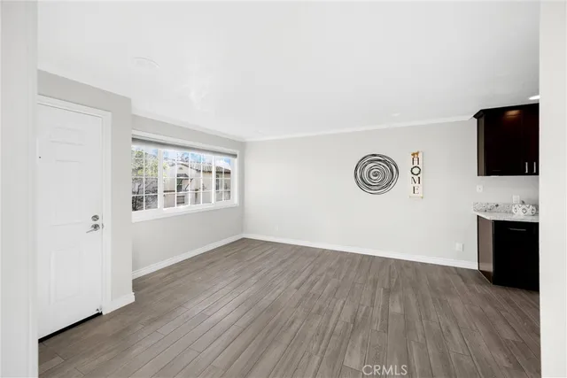an empty room with wooden floor and a window