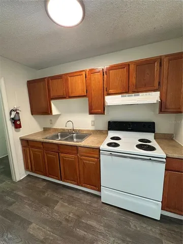 a kitchen with granite countertop a sink stainless steel appliances and cabinets